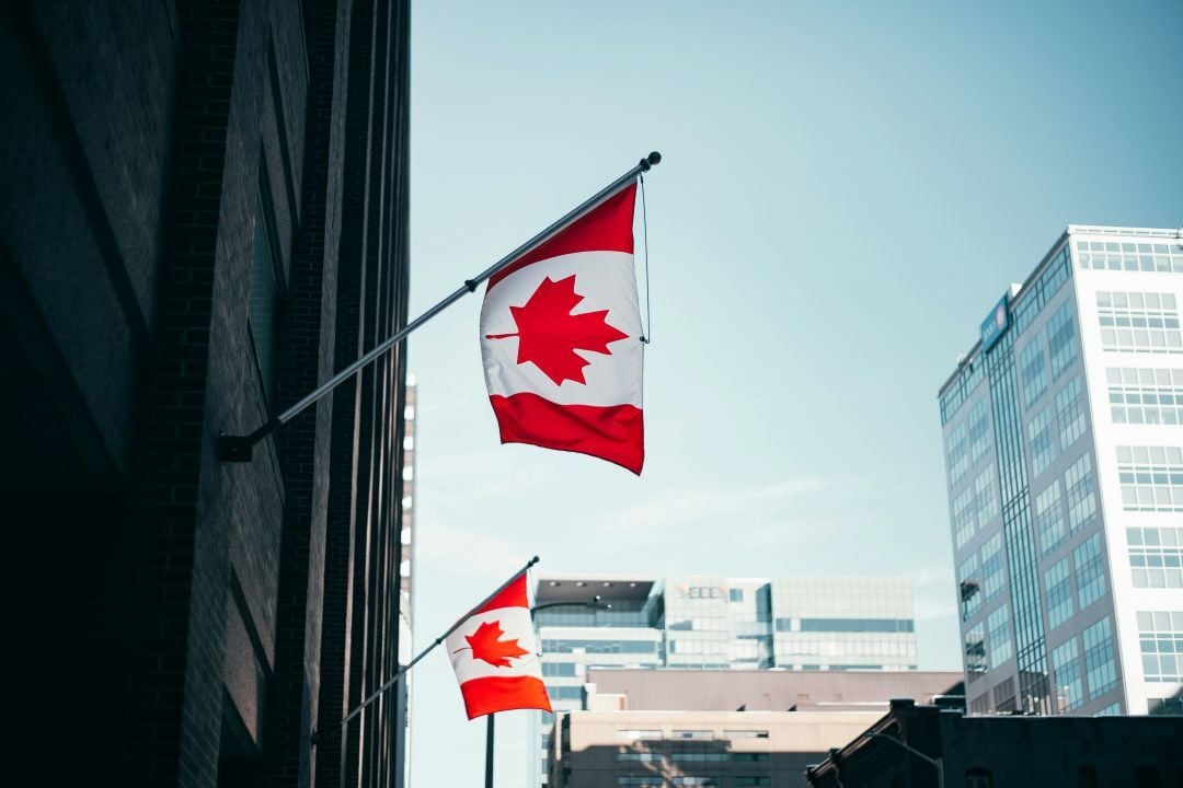 two canadian flags on buildings